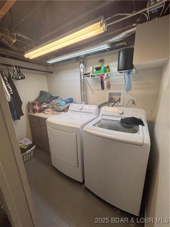 laundry area featuring washer and clothes dryer and cabinet space