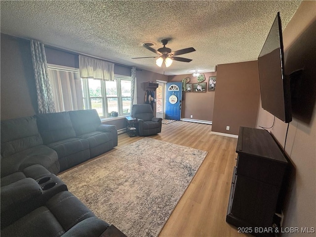 living area with light wood-style floors, a ceiling fan, and a textured ceiling