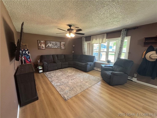 living room featuring wood finished floors, a textured ceiling, a baseboard radiator, a ceiling fan, and baseboards