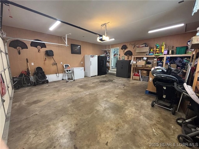 garage featuring freestanding refrigerator and a garage door opener