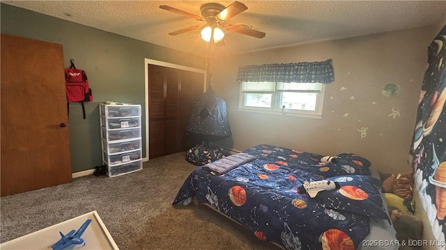 bedroom with a textured ceiling, carpet, a closet, and a ceiling fan