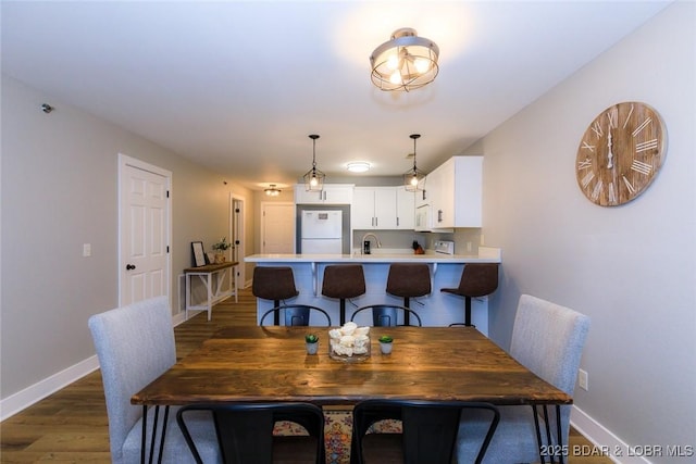 dining space with wood finished floors and baseboards