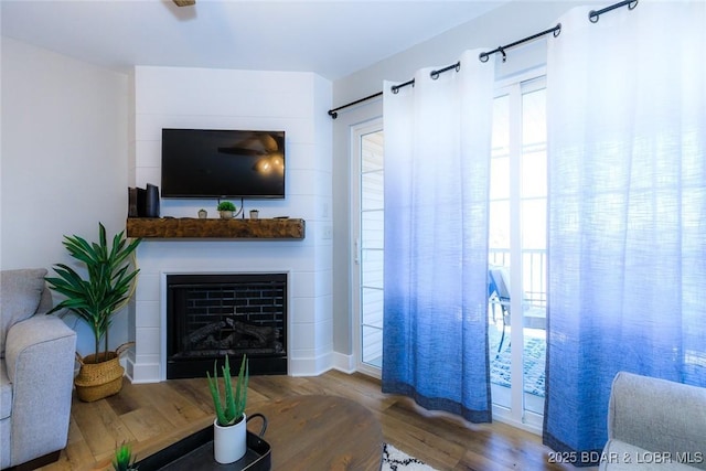 living area with a fireplace and wood finished floors