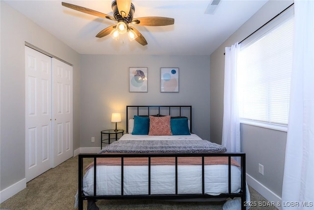 bedroom with carpet flooring, multiple windows, a closet, and baseboards