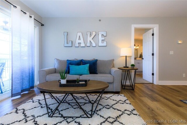 living room with baseboards, plenty of natural light, and wood finished floors