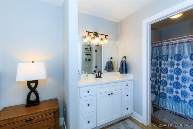 bathroom with toilet, vanity, and a shower with shower curtain