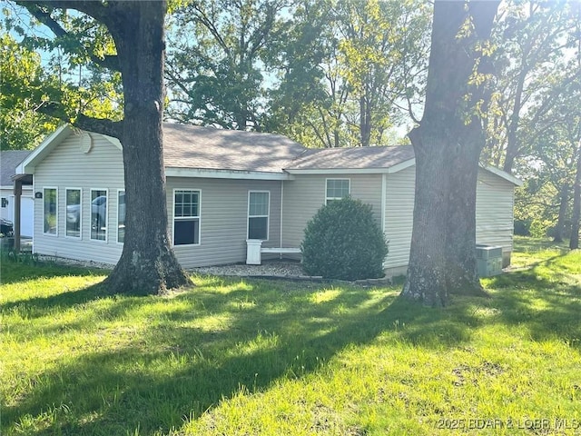 rear view of house featuring a lawn