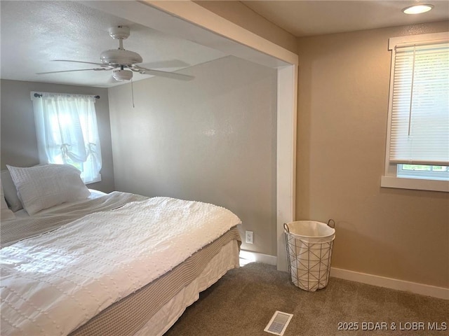 bedroom featuring baseboards, ceiling fan, carpet flooring, and visible vents
