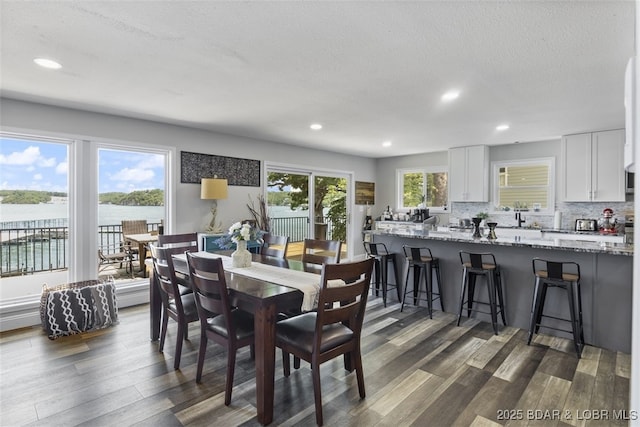 dining room featuring a textured ceiling, dark wood-type flooring, and recessed lighting