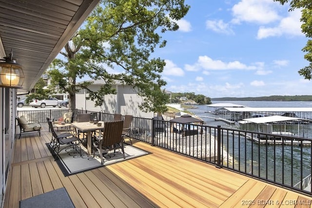 wooden deck with outdoor dining area and a water view