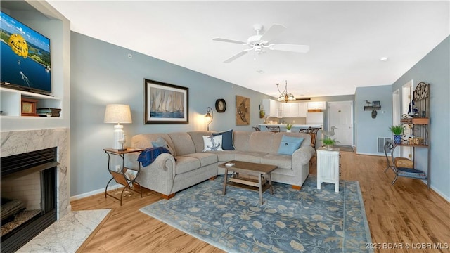 194 Park Place Ln Unit 3C, Kaiser, MO 65047 - living room with a ceiling fan, a high end fireplace, light wood-style flooring, and baseboards