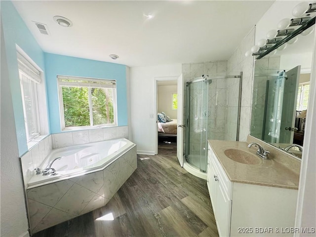 full bathroom with a shower stall, a garden tub, vanity, and wood finished floors