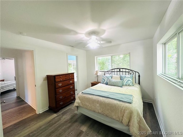 bedroom featuring baseboards, a ceiling fan, visible vents, and wood finished floors