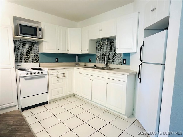 kitchen with backsplash, white cabinetry, a sink, and white appliances