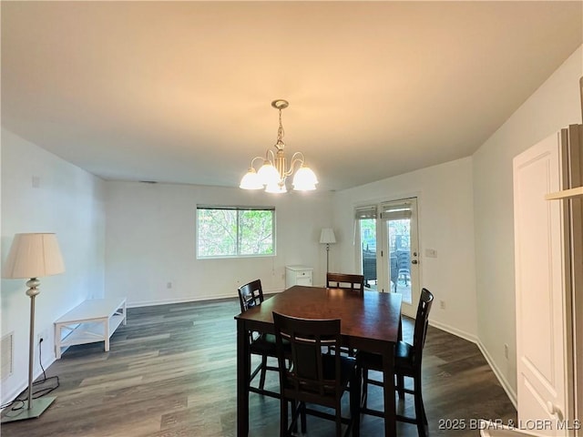 dining area with dark wood-type flooring, baseboards, and a notable chandelier