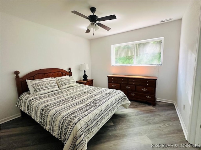 bedroom with visible vents, wood finished floors, and baseboards