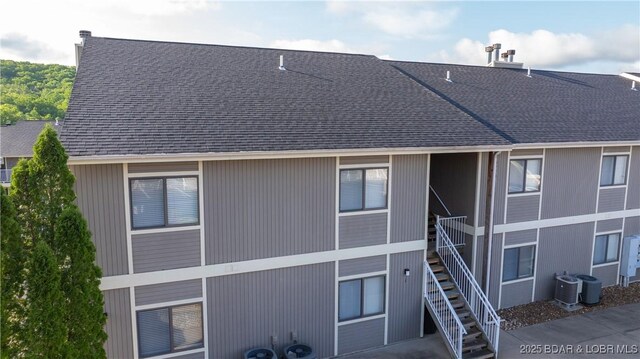 611 Lazy Days Rd Unit L5, Osage Beach, MO 65065 - rear view of property featuring central AC, stairway, and roof with shingles