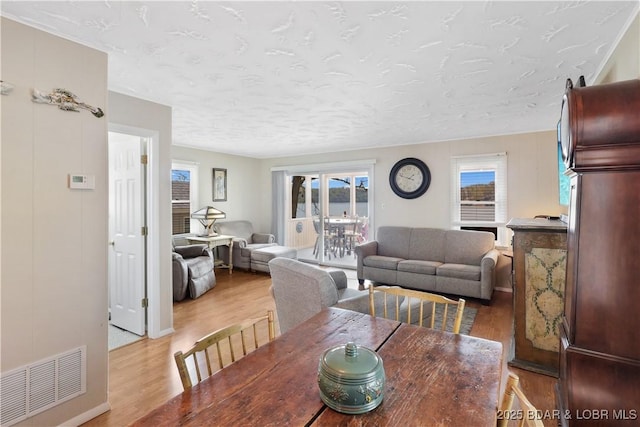 dining room featuring light wood-style flooring and a textured ceiling