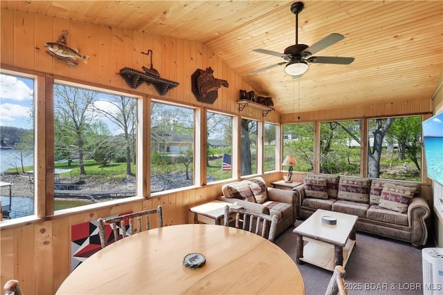 sunroom with wooden ceiling, lofted ceiling, wooden walls, plenty of natural light, and a water view