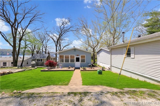 back of house featuring a lawn and a sunroom