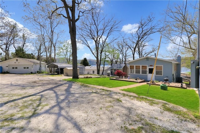 view of grassy yard featuring a detached garage and a carport
