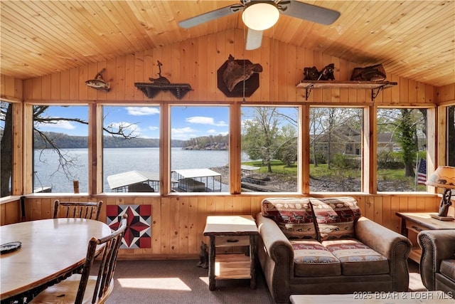 sunroom with vaulted ceiling, wood walls, a water view, wood ceiling, and carpet flooring