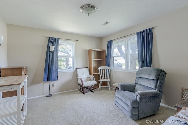 living area featuring baseboards, visible vents, and carpet floors