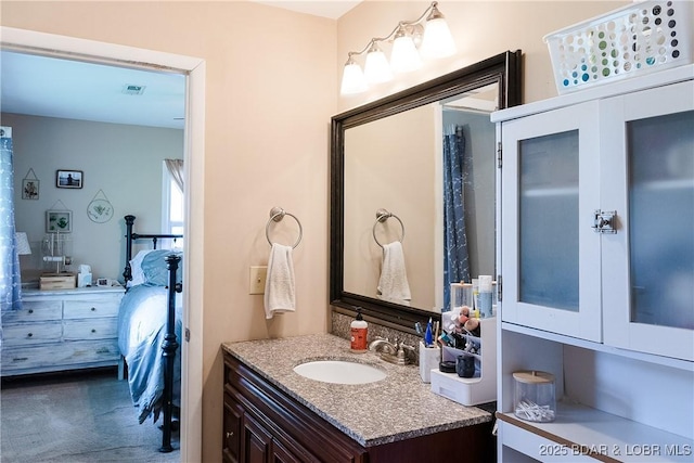 bathroom with ensuite bathroom, visible vents, and vanity