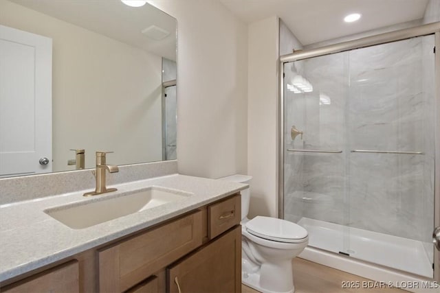 bathroom featuring a stall shower, vanity, toilet, and recessed lighting