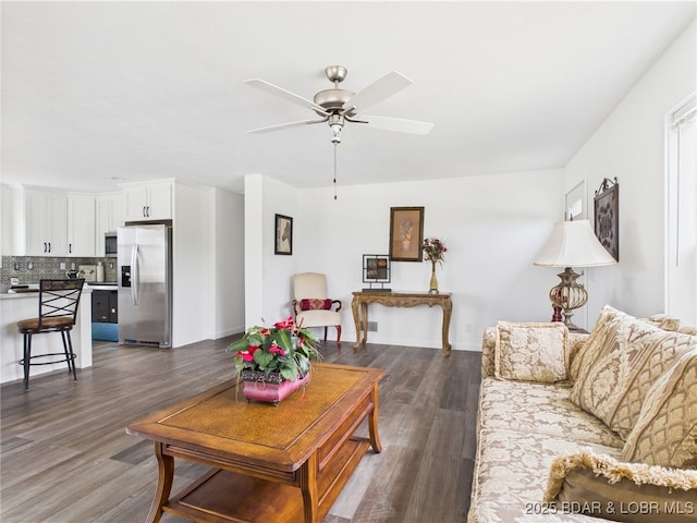 living room with a ceiling fan and dark wood-style floors