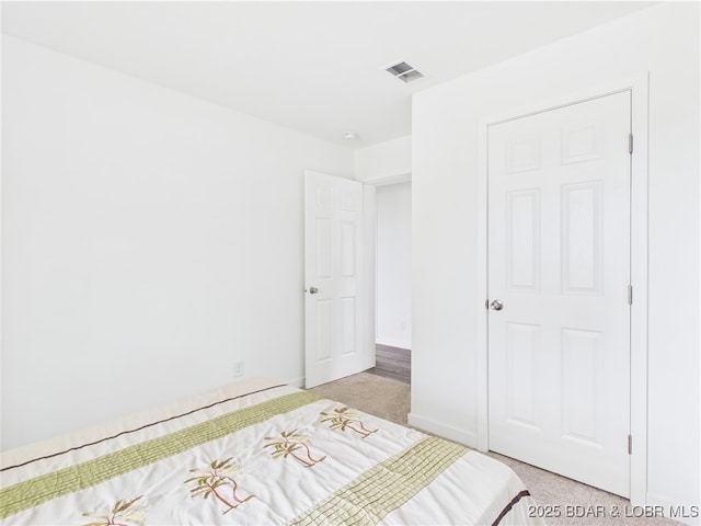 bedroom featuring light carpet and visible vents