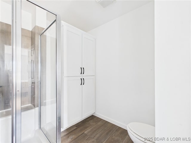 full bathroom featuring baseboards, toilet, visible vents, a shower stall, and wood finished floors