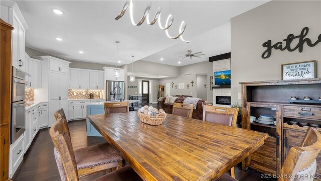 484 Hogan Dr, Lake Ozark, MO 65049 - dining space featuring recessed lighting, a stone fireplace, dark wood-style flooring, and ceiling fan