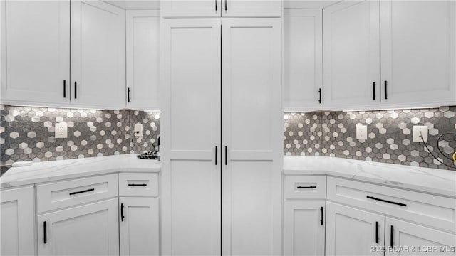 484 Hogan Dr, Lake Ozark, MO 65049 - kitchen featuring white cabinets, tasteful backsplash, and light stone counters