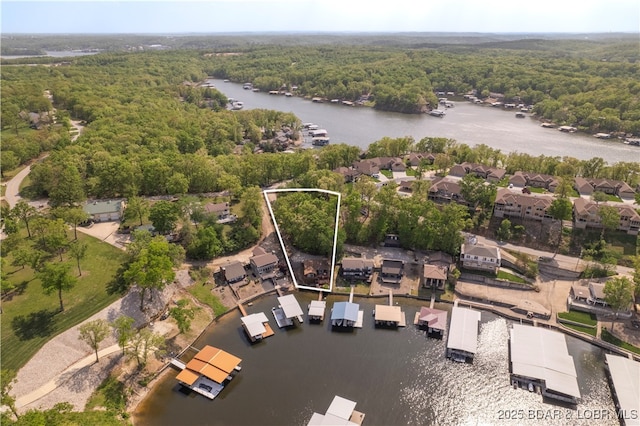 aerial overview of property's location featuring a heavily wooded area, property boundaries highlighted, and a large body of water