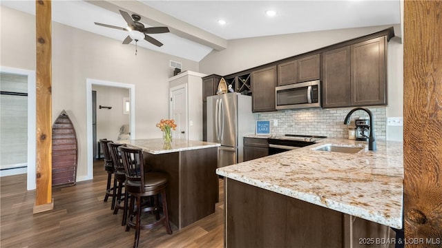 31445 Raytown Dr, Rocky Mount, MO 65072 - kitchen with dark brown cabinets, a sink, backsplash, stainless steel appliances, and vaulted ceiling with beams