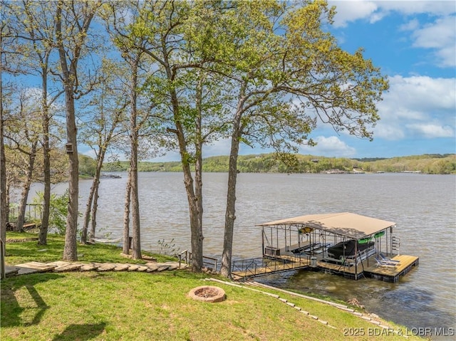 view of dock featuring an outdoor fire pit, a yard, and a water view