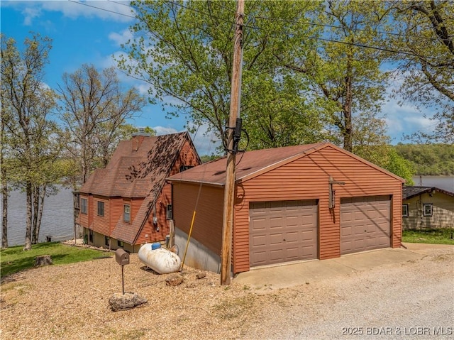 view of front of home featuring a shingled roof and a detached garage