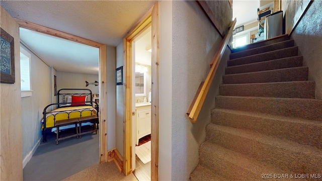 staircase featuring carpet floors and baseboards
