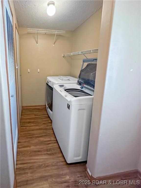 12448 Crestview Dr, Warsaw, MO 65355 - laundry area with light wood finished floors, separate washer and dryer, laundry area, a textured ceiling, and baseboards