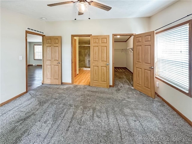 12448 Crestview Dr, Warsaw, MO 65355 - unfurnished bedroom featuring carpet, a closet, a walk in closet, baseboards, and ceiling fan