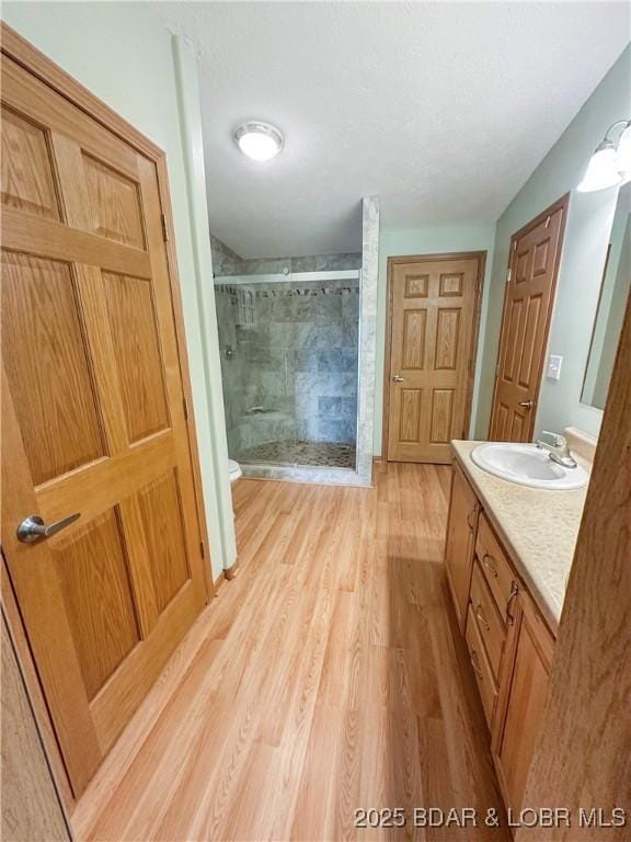 12448 Crestview Dr, Warsaw, MO 65355 - full bathroom with a shower stall, vanity, toilet, and wood finished floors
