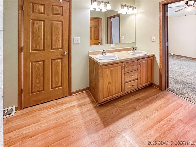 12448 Crestview Dr, Warsaw, MO 65355 - full bathroom featuring double vanity, visible vents, wood finished floors, and a sink
