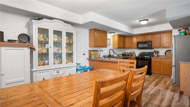 93 Misty Meadows Ln, Camdenton, MO 65020 - kitchen with black appliances, a sink, light wood-type flooring, and brown cabinetry