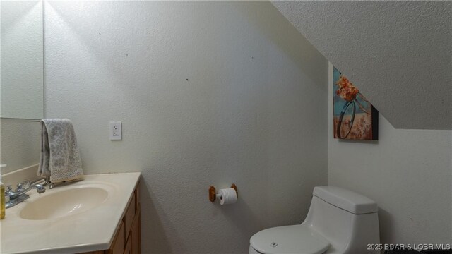 93 Misty Meadows Ln, Camdenton, MO 65020 - bathroom featuring toilet, lofted ceiling, vanity, and a textured ceiling