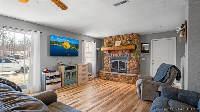 93 Misty Meadows Ln, Camdenton, MO 65020 - living area featuring wood finished floors, healthy amount of natural light, a stone fireplace, a ceiling fan, and recessed lighting