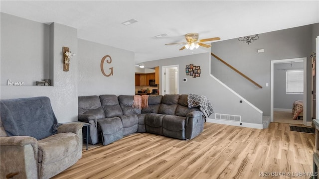 93 Misty Meadows Ln, Camdenton, MO 65020 - living room with light wood-style flooring, a ceiling fan, stairs, and baseboards