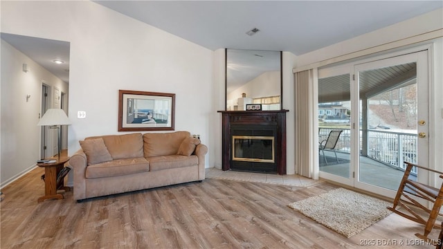 141 Wye Dr, Lake Ozark, MO 65049 - living room featuring wood finished floors, a glass covered fireplace, and baseboards