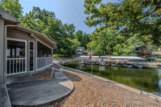 141 Wye Dr, Lake Ozark, MO 65049 - view of yard with a water view, a dock, a sunroom, and view of wooded area