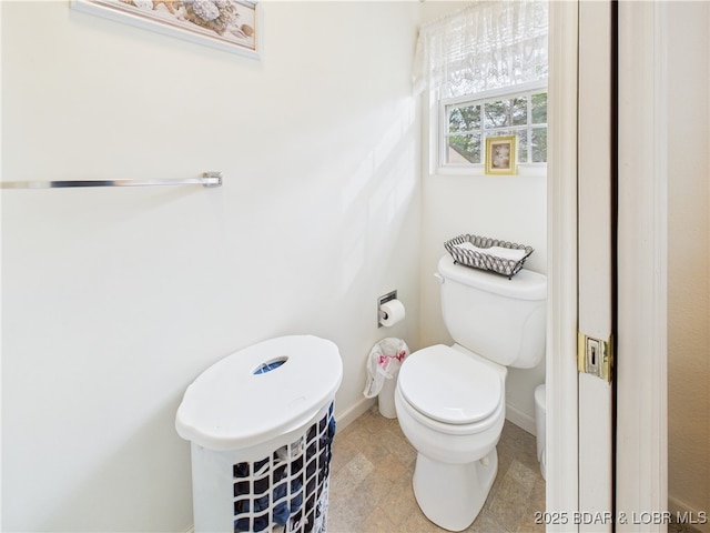bathroom with toilet and baseboards
